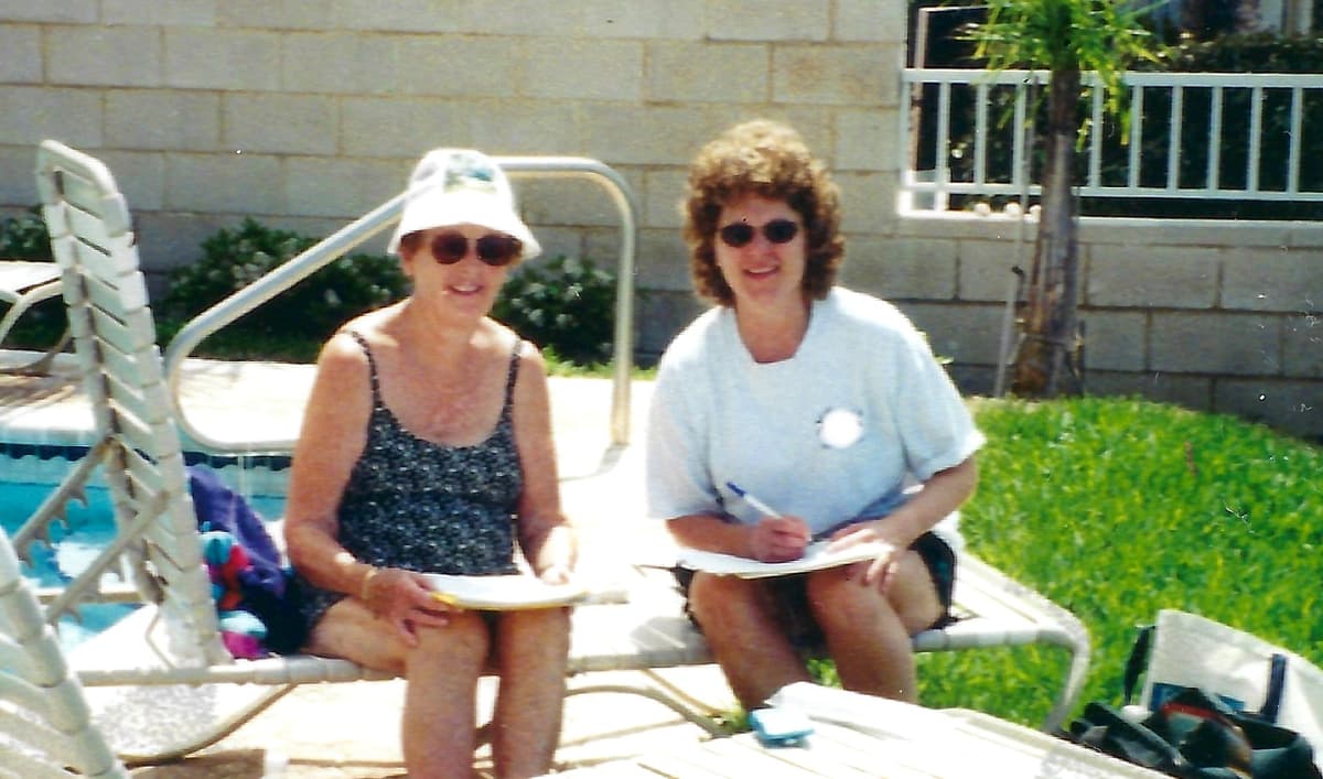 Photo of Katie writing a workout plan with her mother outdoors.